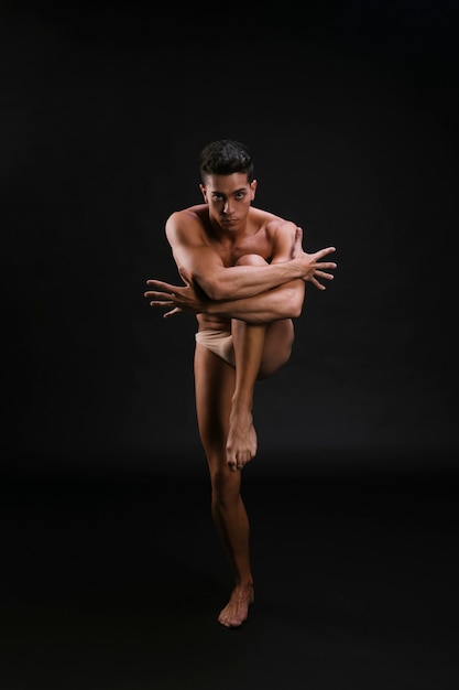 Young dancer embracing knee