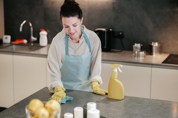 Foto gratuita giovane donna dai capelli scuri che sembra occupata mentre fa i lavori domestici