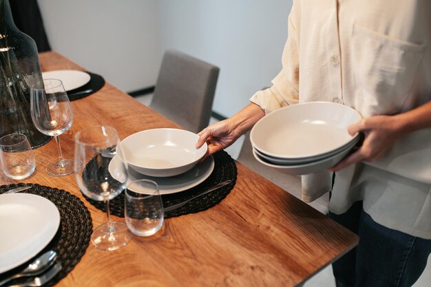 Young dark-haired woman serving the table in the kitchen