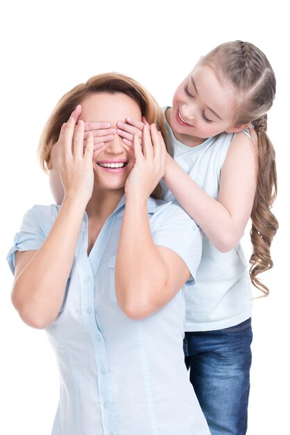 Young daughter closes hands eyes mom - isolated