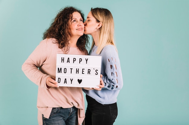 Young daughter kissing mom on Mother's Day