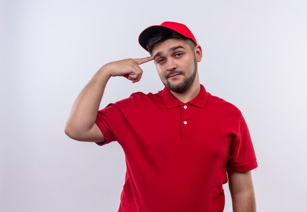 작업에 초점을 맞춘 그의 사원을 가리키는 자신감을 찾고 빨간색 유니폼과 모자 젊은 배달 소년