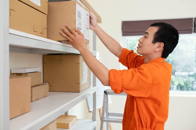 Free photo young delivery man preparing parcels for delivery