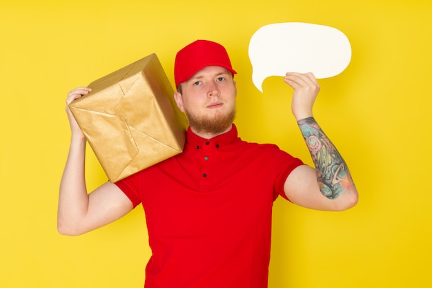 young delivery man in red polo red cap white jeans holding a box on yellow