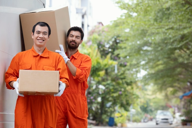 Free photo young delivery men moving parcel boxes