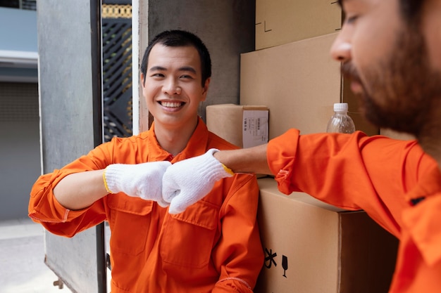 Free photo young delivery men saluting each other with fist bump