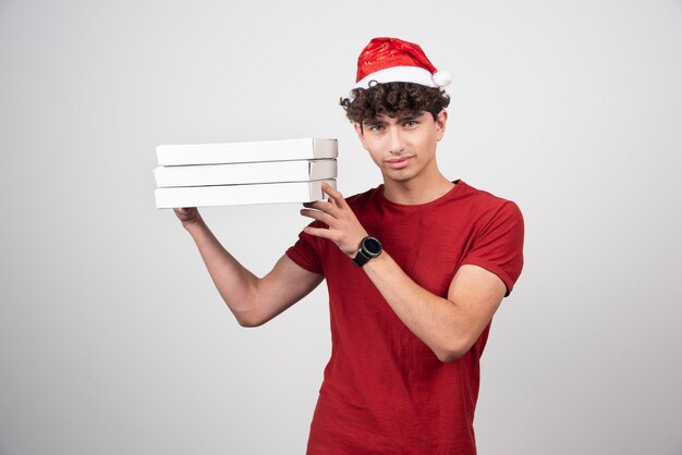 young deliveryman with pizza boxes standing  