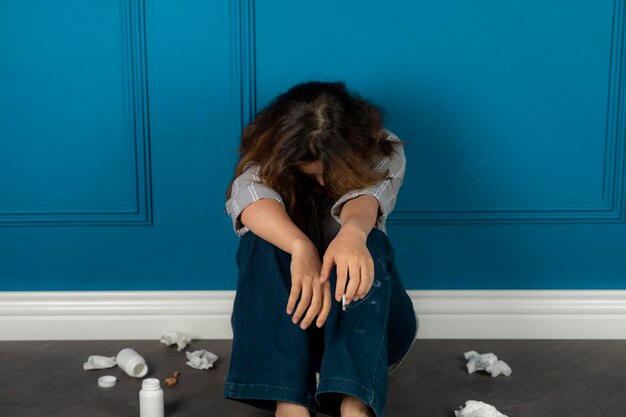 A young depressed girl sitting on the floor and crying. High quality photo