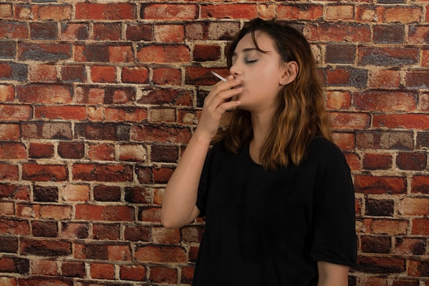 Giovane ragazza depressa che fuma sigaretta. foto di alta qualità