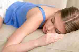 Free photo young deprived sleeping woman lying asleep on sofa, close up