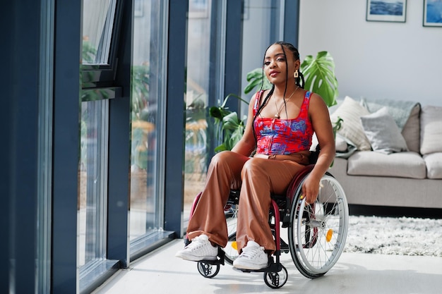 Foto gratuita giovane donna afroamericana disabile in sedia a rotelle a casa