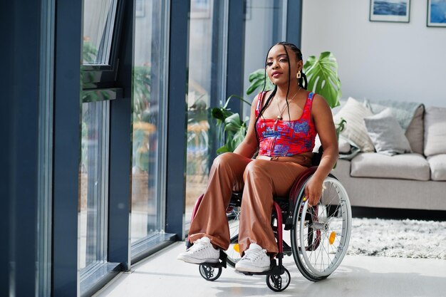 집에서 휠체어를 탄 젊은 장애인 흑인 여성