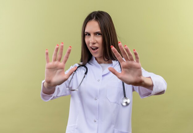 Young doctor girl wearing stethoscope medical gown - on green wall