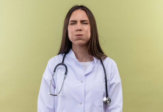 Young doctor girl wearing stethoscope medical gown - on green wall