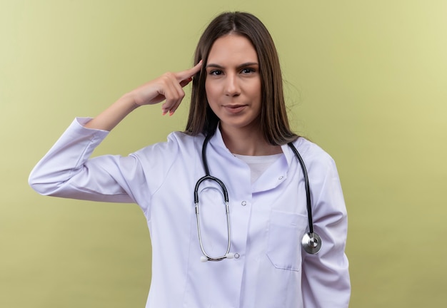 Young doctor girl wearing stethoscope medical gown - on green wall