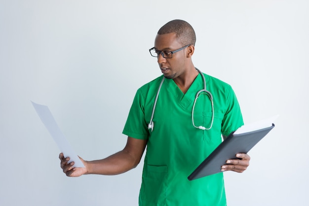 Young doctor looking at medical test results. 