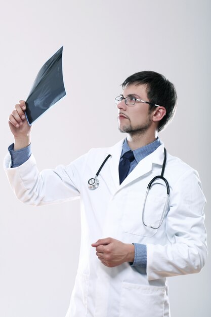 Young doctor looking at x-ray image