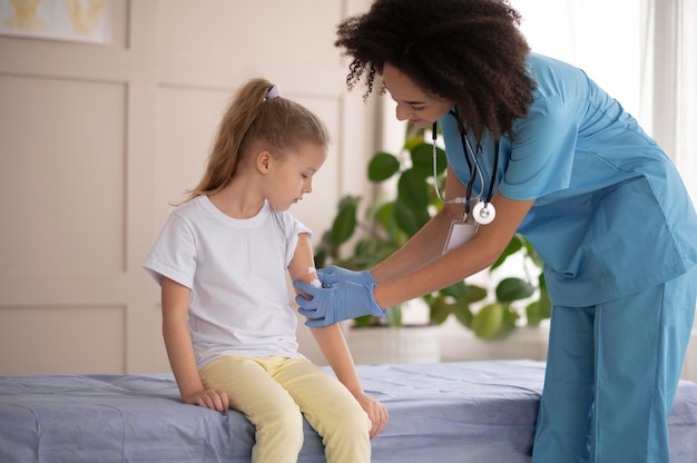 Giovane medico che si assicura che una bambina stia bene dopo la vaccinazione