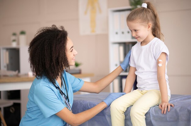 young doctor making sure a little girl is fine after vaccination