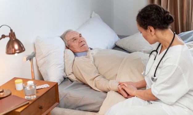 Free photo young doctor talking with her senior patient