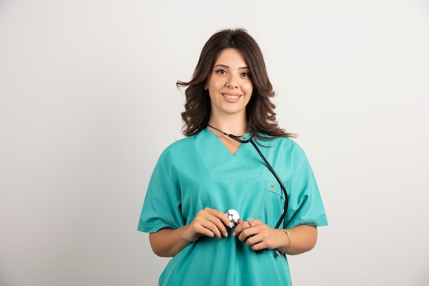 Free photo young doctor using stethoscope on white.