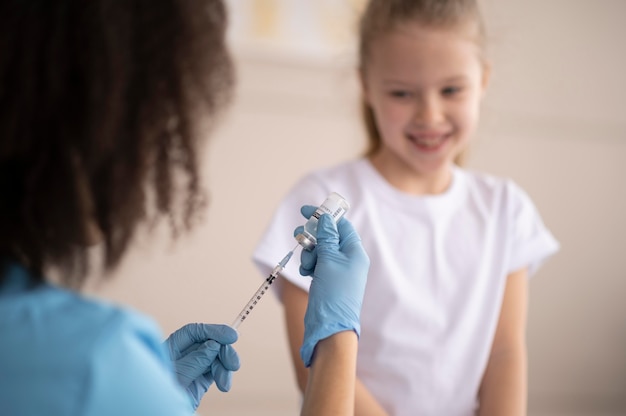 少女に予防接種をする若い医者