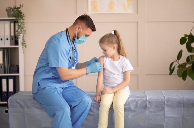 少女に予防接種をする若い医者
