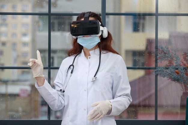 Young doctor wearing VR glasses and point finger up High quality photo