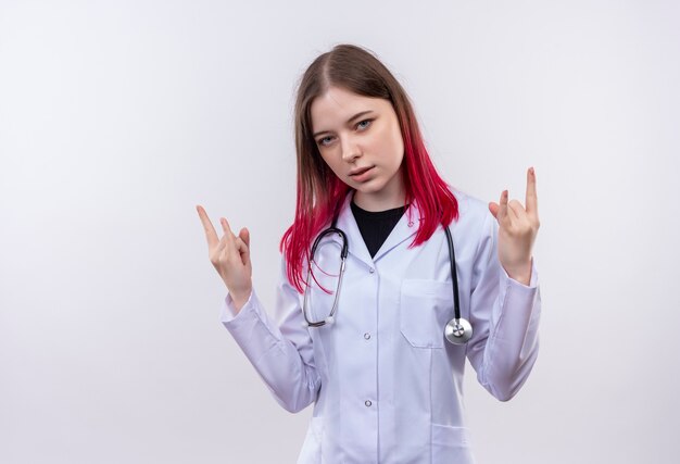  young doctor woman wearing stethoscope medical robe showing goat gesture on isolated white wall with copy space