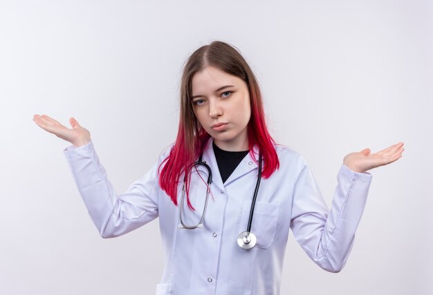  young doctor woman wearing stethoscope medical robe spreads hands on isolated white wall