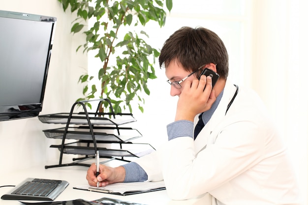 Young doctor working in his office