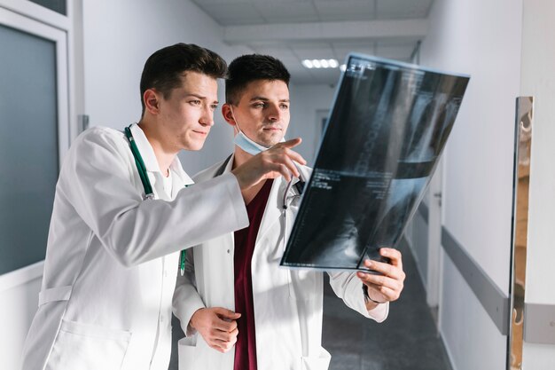 Молодые врачи, указывая на рентгеновский снимок