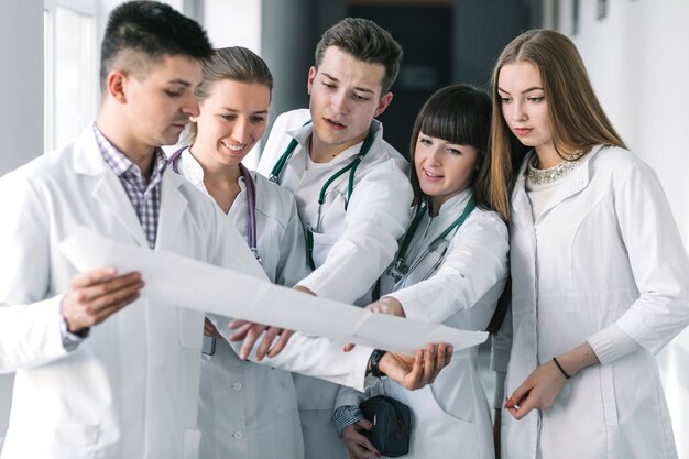 Young doctors with cardiogram in hospital