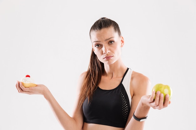 Young doubting sportswoman choosing