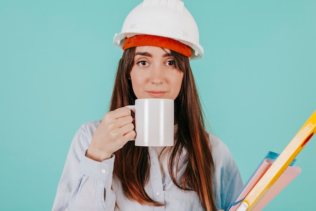 Young draftswoman with hot beverage