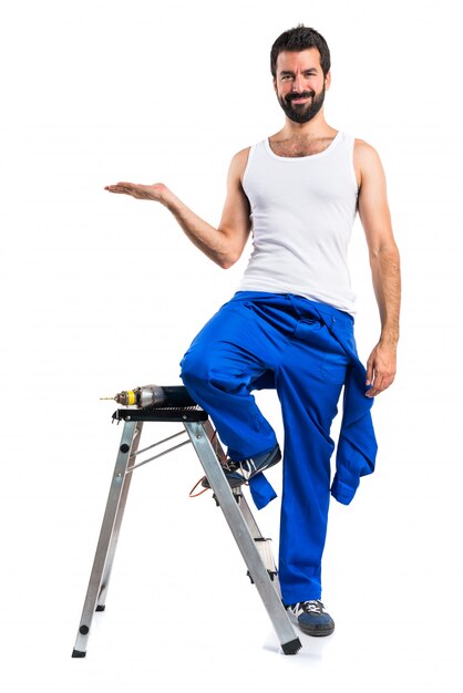 Young electrical technician with a drill and holding something