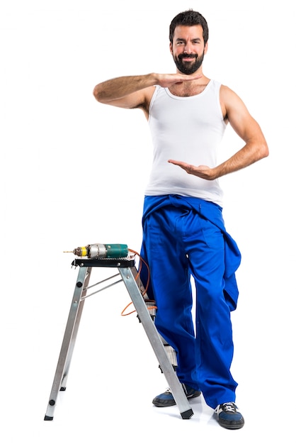 Young electrical technician with a drill and holding something