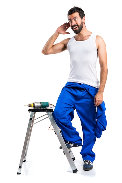 Young electrical technician with a drill listening something