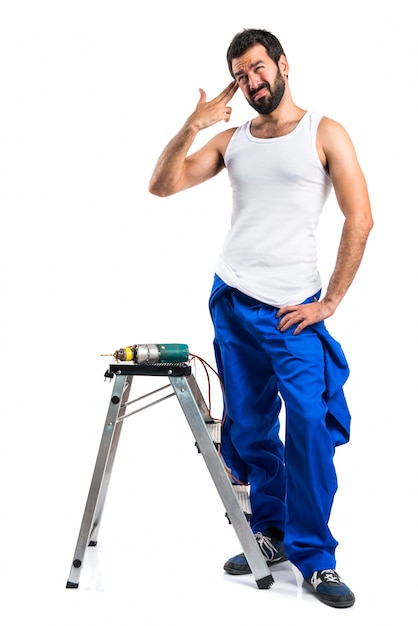 Free photo young electrical technician with a drill making suicide gesture