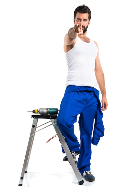 Young electrical technician with a drill pointing to the front