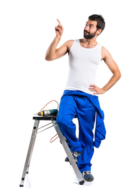 Young electrical technician with a drill pointing up