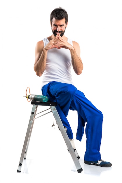 Young electrical technician with a drill thinking