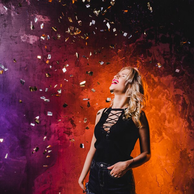 Young elegant girl in falling confetti