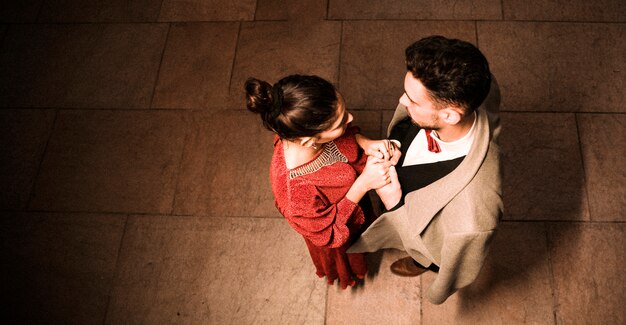 Young elegant man holding hands with charming woman