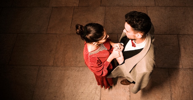 Young elegant man holding hands with charming woman