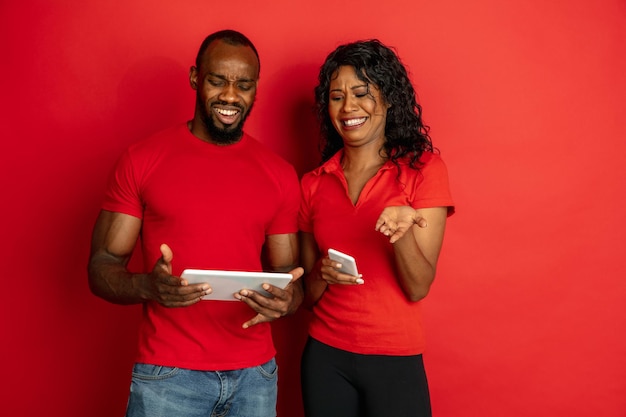 Молодой эмоциональный афро-американский мужчина и женщина на красном