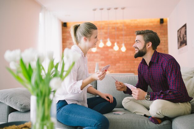 Young emotional couple playing cards