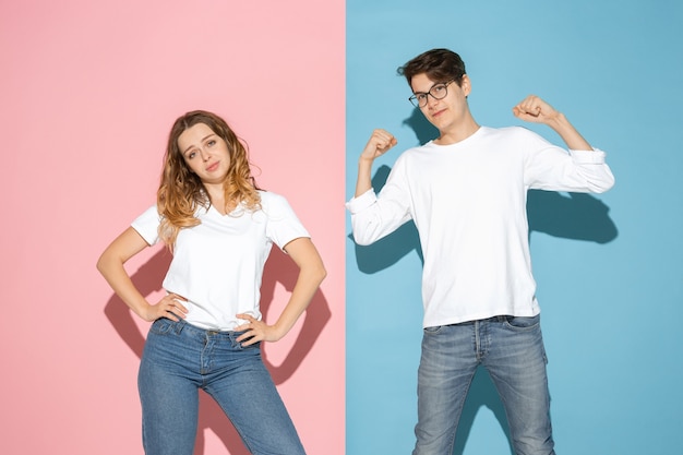 Young emotional man and woman on pink and blue