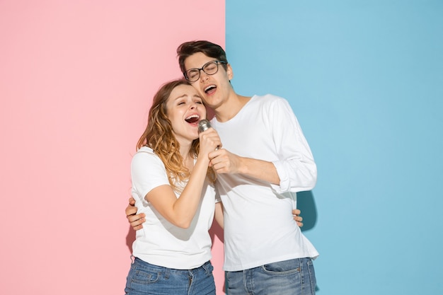 Young emotional man and woman on pink and blue