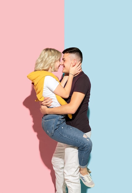 Free photo young emotional man and woman on pink and blue
